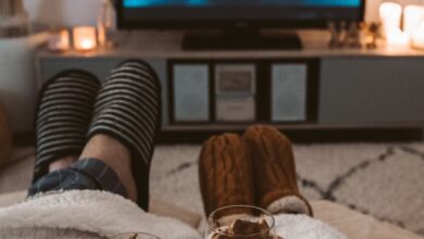 Weighted Blankets - A couple enjoys a cozy movie night with drinks, wrapped in blankets, watching a Harry Potter film on TV.