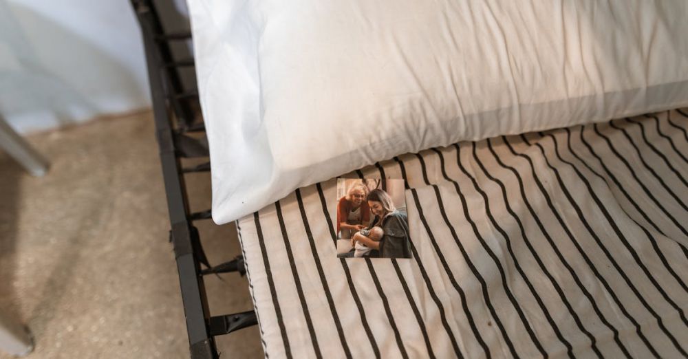 Memory Foam Pillows - A high angle shot of a bed with striped sheets, a pillow, and a family photo.