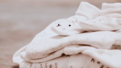 Sleep Essentials - Close-up of soft white baby clothes with cute animal patterns, ideal for newborn comfort.