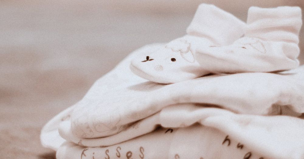 Sleep Essentials - Close-up of soft white baby clothes with cute animal patterns, ideal for newborn comfort.