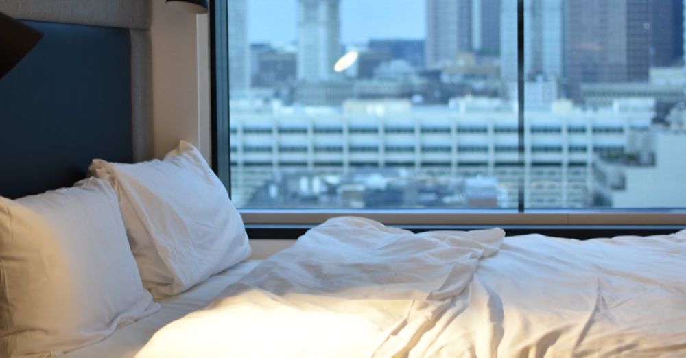 Travel Pillows - Modern hotel room overlooking Boston skyline, featuring luxury bedding.