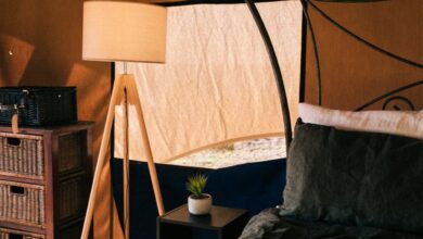 Bedside Storage - Comfortable bed with bedside table and lamp under tent roof with covered window