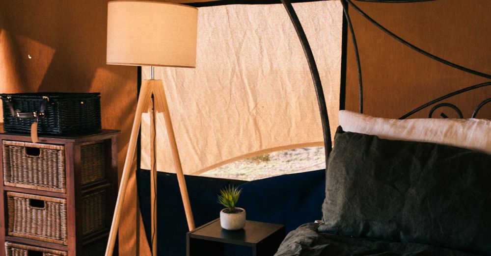 Bedside Storage - Comfortable bed with bedside table and lamp under tent roof with covered window