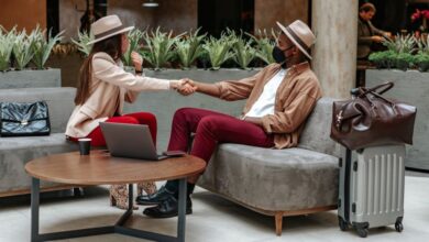 Smart Suitcases - Two fashionable individuals shaking hands in a hotel lobby, showcasing travel and safety.