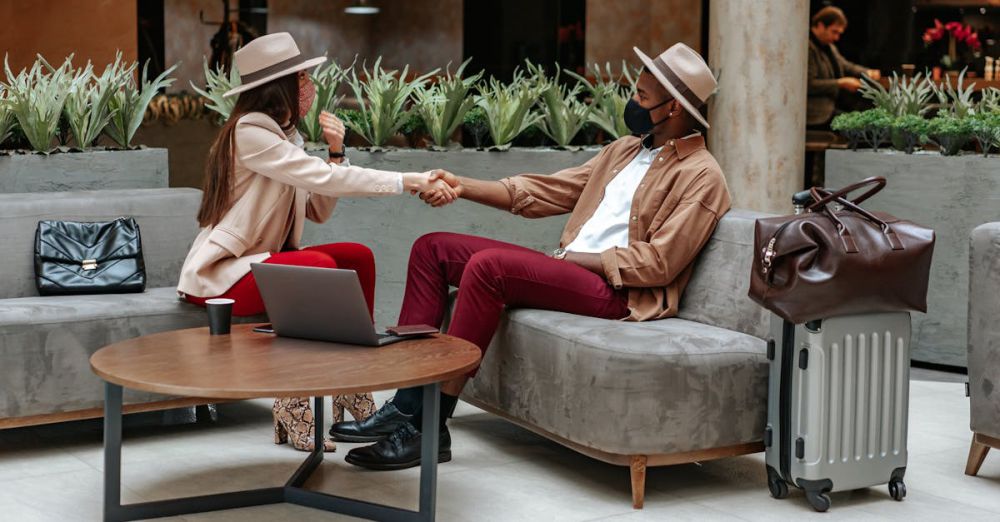 Smart Suitcases - Two fashionable individuals shaking hands in a hotel lobby, showcasing travel and safety.