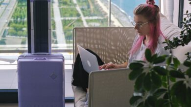 Luggage Trackers - Woman in White and Pink Floral Shirt Using Macbook