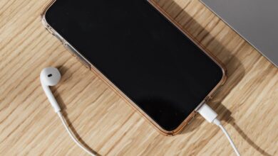 Portable Chargers - Modern workspace featuring a smartphone, laptop, and earphones on a wooden table.