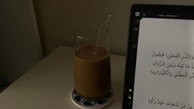 Translation Devices - A tablet displaying Arabic text beside a glass of coffee with straw on a desk.