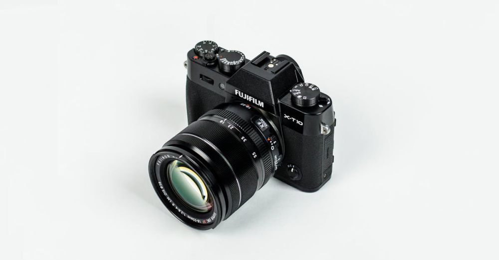 Products - Close-up of a Fujifilm camera with lens on a plain background, showcasing photographic equipment.