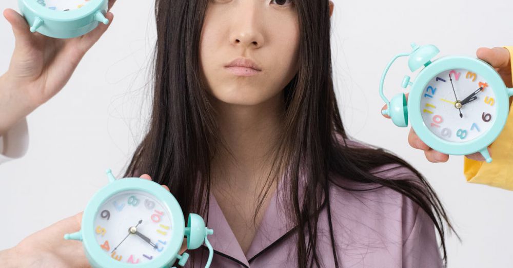 Alarm Clocks - Asian woman in pajamas with alarm clocks, illustrating insomnia concept.