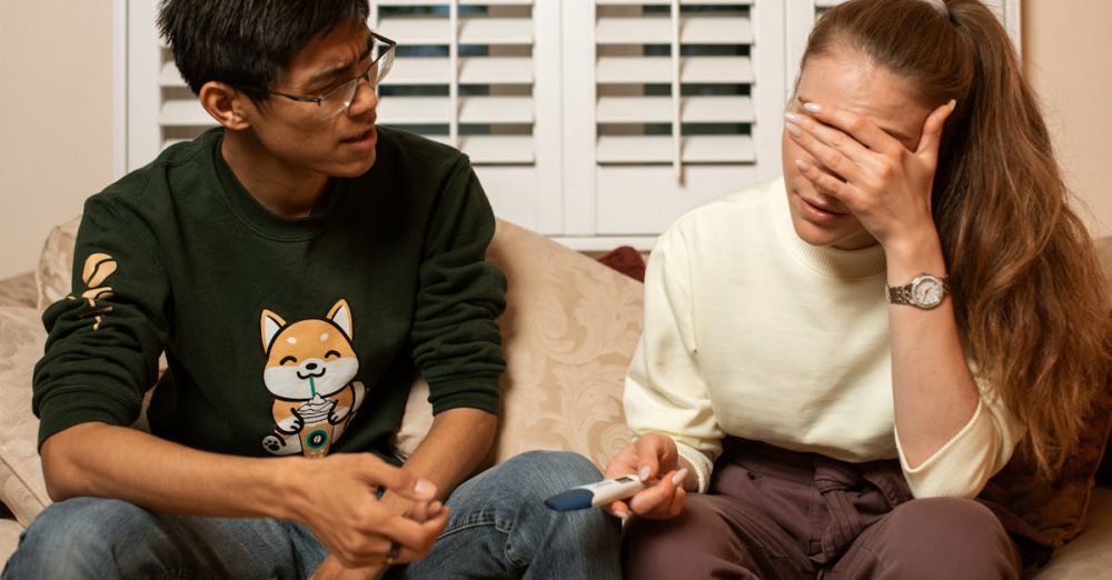 Family Plans - A couple on a sofa sharing an emotional moment with a pregnancy test.