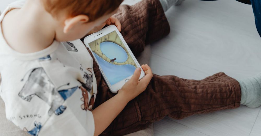 Educational Apps - A young child playing an educational game on a smartphone indoors, focused on learning.