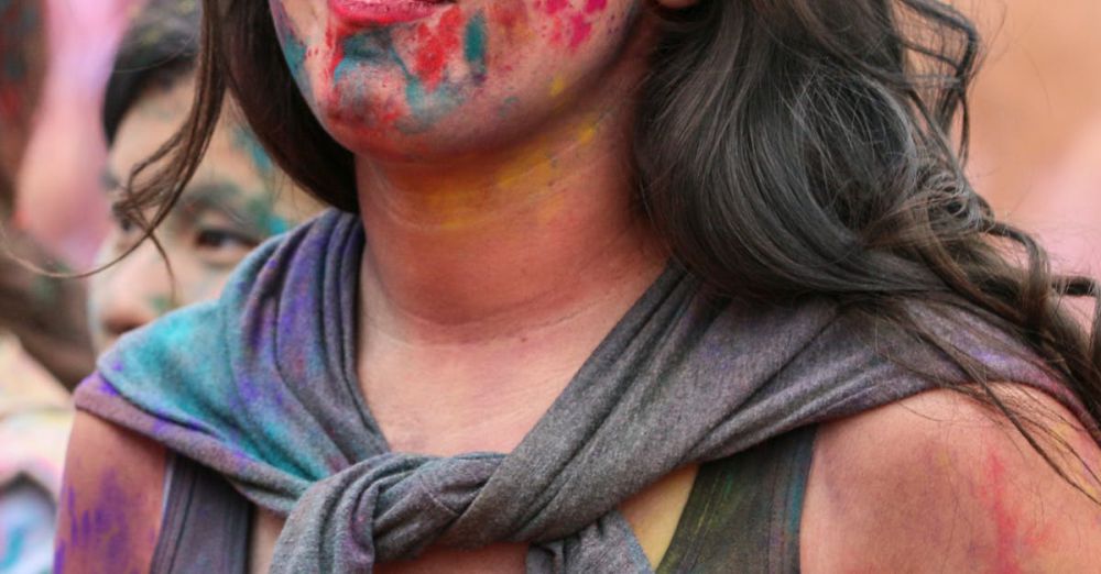 Photography Subscriptions - A woman joyfully participates in a Holi festival, covered in bright colorful powders.