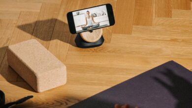 Fitness Streaming - A serene home yoga setup with phone streaming class and mat.