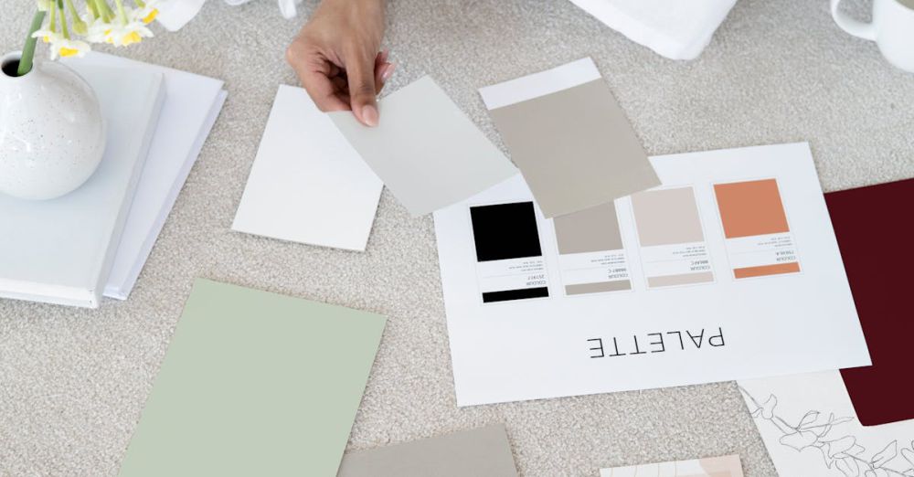 Small Business Plans - Designer sits on carpet with color palettes and samples, planning creative project.