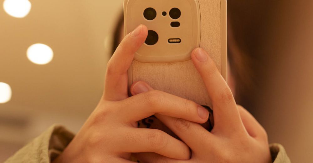 Phone Grips - Close-up shot of hands holding a smartphone indoors, focused on back cover.