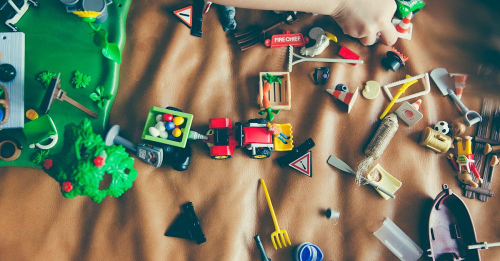 Toys - Children's hands playing with colorful toys on a mat, sparking creativity and fun.