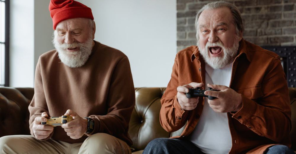 Gaming Controllers - Two senior men laughing and playing video games, sharing joyful moments indoors.