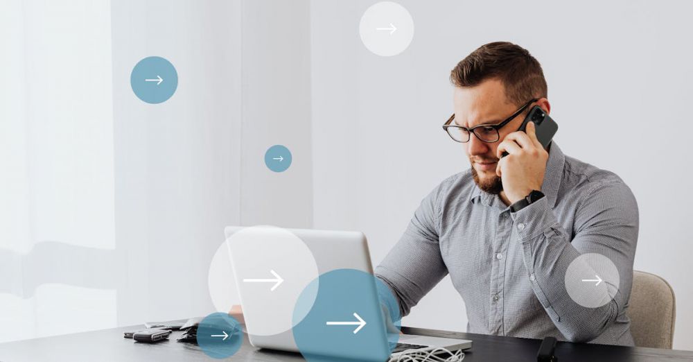 Charging Cables - Professional man multitasks with laptop and smartphone in home office environment.