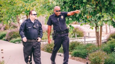 Anti-Glare Protectors - Two police officers walking along a park path in uniform, ensuring public safety.