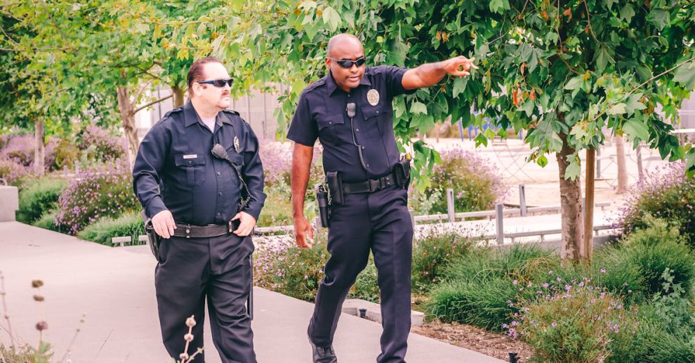 Anti-Glare Protectors - Two police officers walking along a park path in uniform, ensuring public safety.