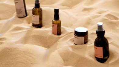 Moisturizers - Explore a unique arrangement of beauty products on a textured sand surface, offering a natural aesthetic.