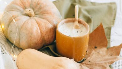 Night Creams - A warm fall setup featuring pumpkins, a hot drink, and autumn leaves.