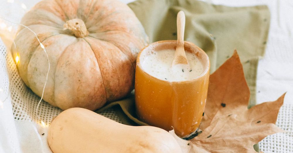 Night Creams - A warm fall setup featuring pumpkins, a hot drink, and autumn leaves.