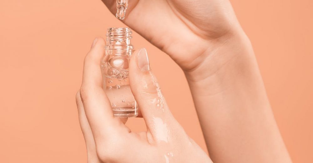 Skin Serums - Close-up of hands using a dropper to apply skincare serum, ideal for health and beauty content.