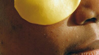 Collagen Boosters - Close-up of a woman applying gold under-eye patches for skincare treatment.