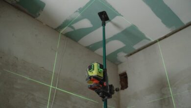 Laser Levels - A laser level tool in action at an indoor construction site with marked walls.