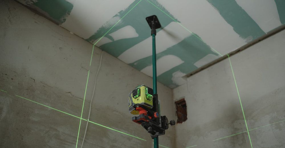 Laser Levels - A laser level tool in action at an indoor construction site with marked walls.