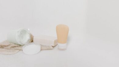 Soap - Minimalist setup of skincare products including cream, soap, and lotion on a white surface for beauty and self-care themes.