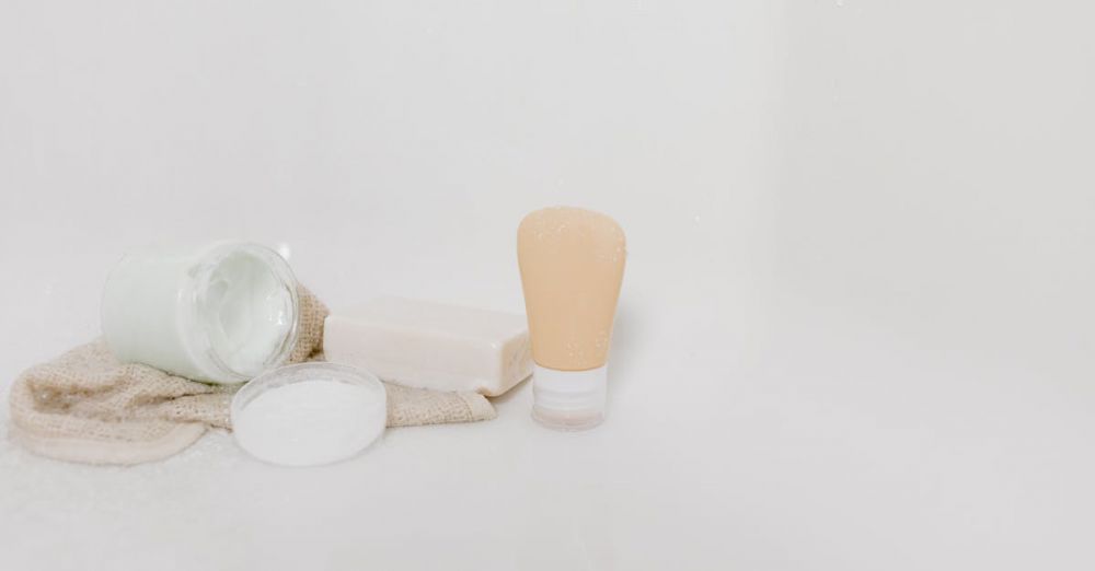 Soap - Minimalist setup of skincare products including cream, soap, and lotion on a white surface for beauty and self-care themes.