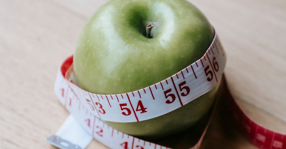 Tape Measures - A green apple encircled by a measuring tape, symbolizing diet and fitness goals.