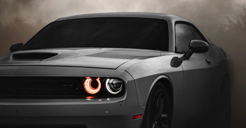 Impact Drivers - Dodge Challenger sports car in a dramatic, cloudy outdoor setting. Ideal for automotive enthusiasts.