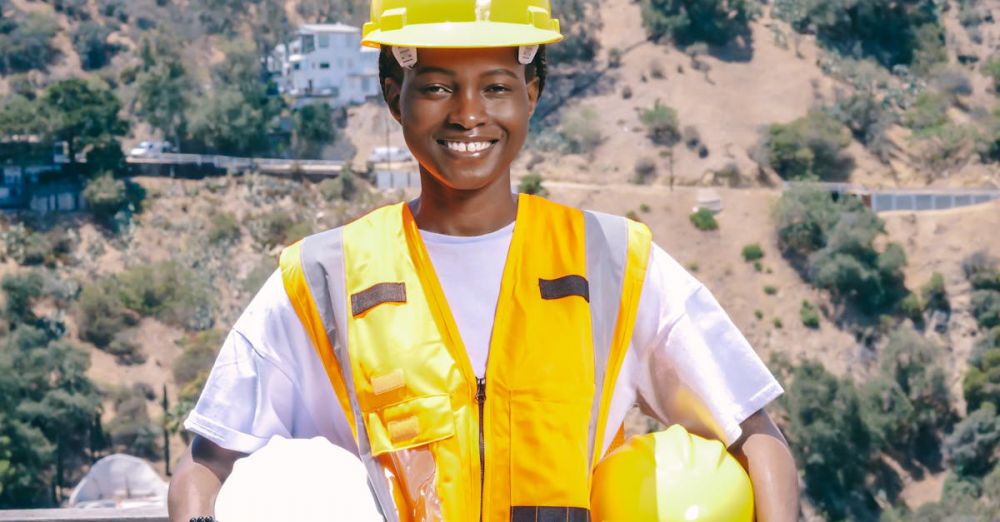 Work Gloves - Outdoor portrait of an engineer smiling in safety gear, showcasing PPE essentials.