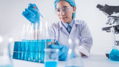 Safety Goggles - A female scientist using lab equipment for research in a modern laboratory setting.