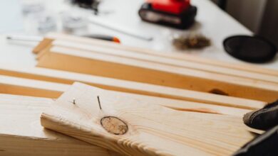 Nail Guns - Close-up of woodworking, showing a power drill and wooden planks for DIY projects.