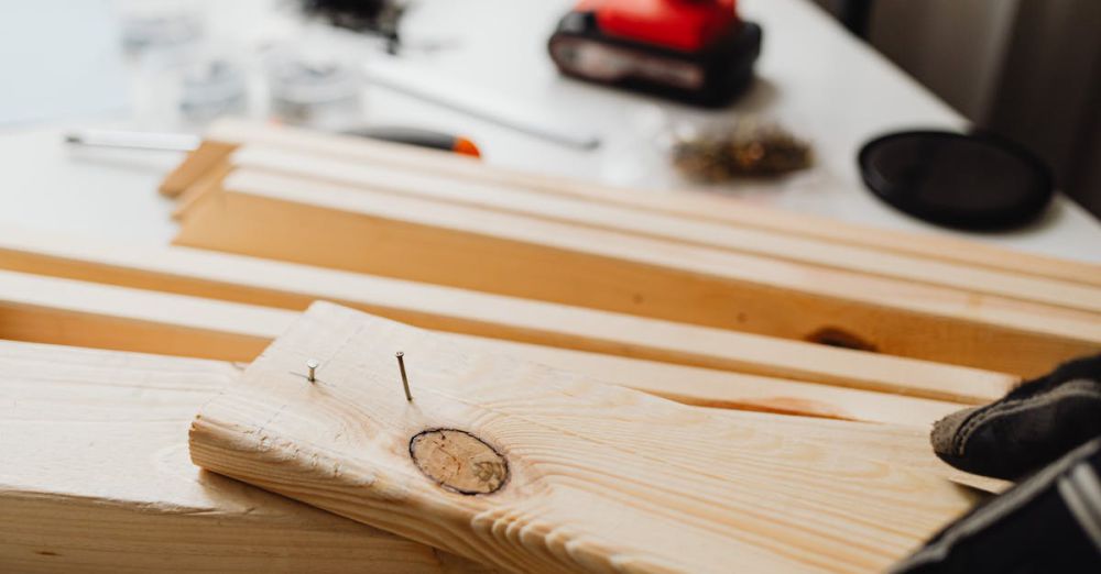 Nail Guns - Close-up of woodworking, showing a power drill and wooden planks for DIY projects.