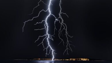 Bolt Cutters - Dramatic lightning bolt over the ocean at night, illuminating the coastal landscape.