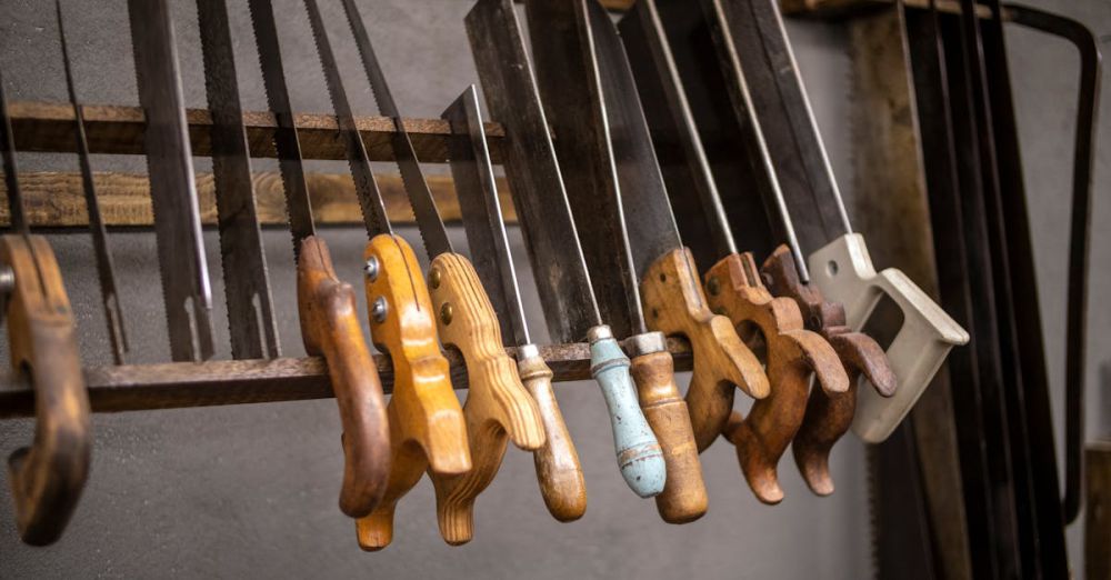 Hand Saws - Assorted vintage hand saws with wooden handles neatly displayed in a workshop setting.