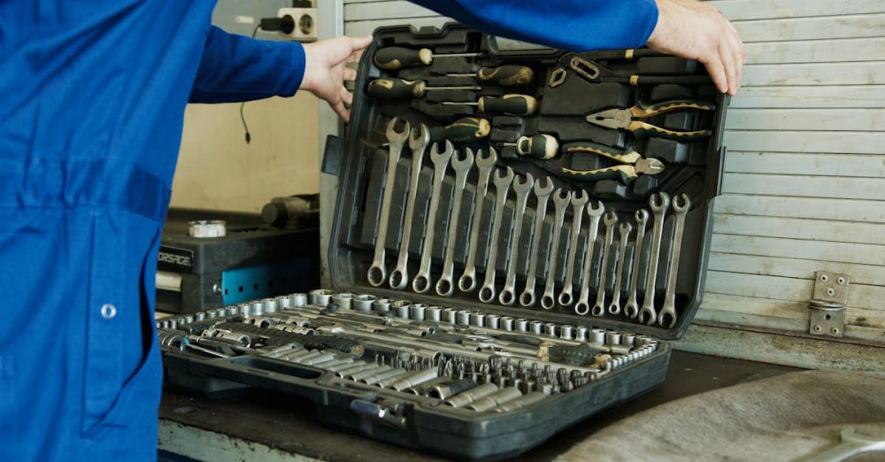 Wrenches - Mechanic organizing a comprehensive tool set for vehicle maintenance in a workshop setting.