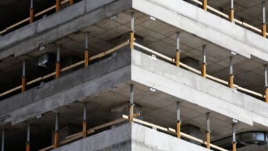 Levels - Close-up of an unfinished multi-level concrete building with steel reinforcements.