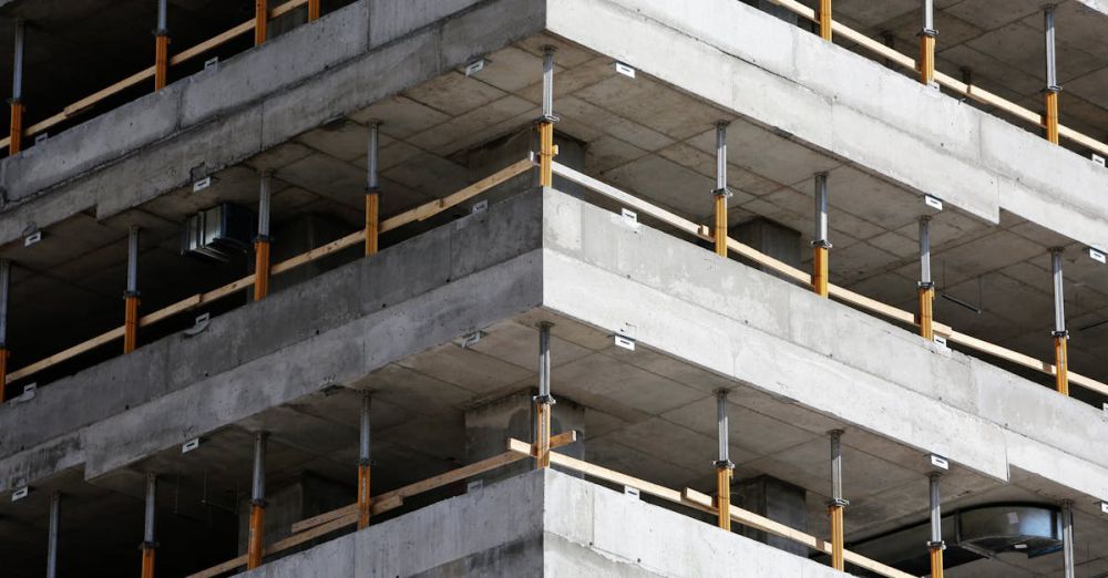 Levels - Close-up of an unfinished multi-level concrete building with steel reinforcements.