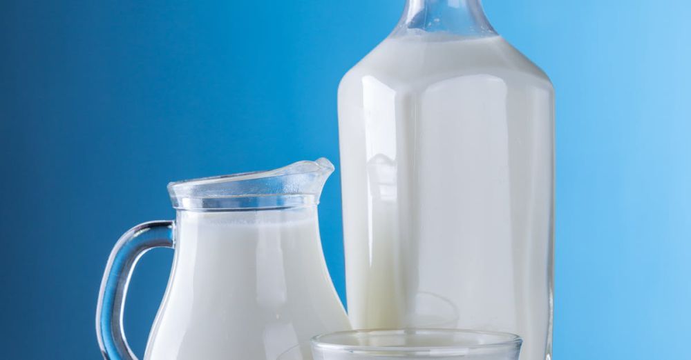 Products - Minimalist still life of fresh milk in glassware against a blue background.