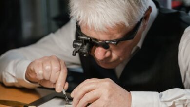 Vintage Watches - An experienced watchmaker meticulously repairing a watch at a well-lit workshop table.