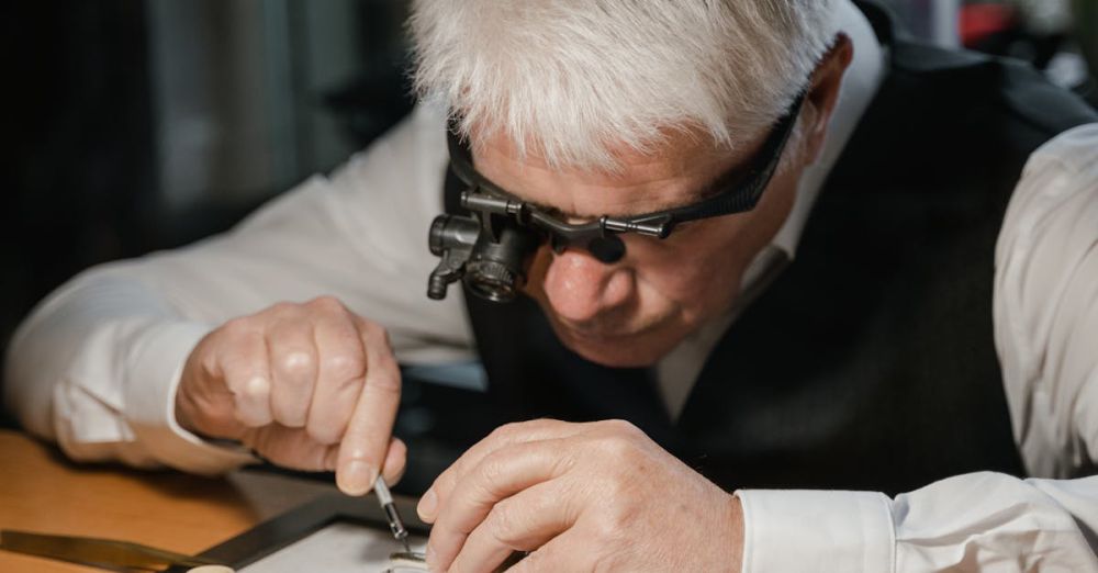 Vintage Watches - An experienced watchmaker meticulously repairing a watch at a well-lit workshop table.