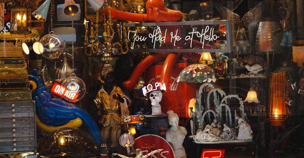 Memorabilia - An eclectic display of antiques in a shop window featuring neon signs and retro decor.