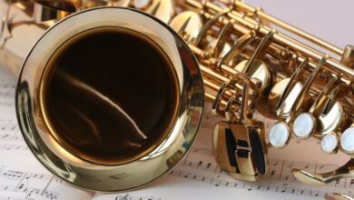 Instruments - A detailed view of a saxophone resting on sheet music, highlighting its brass finish.